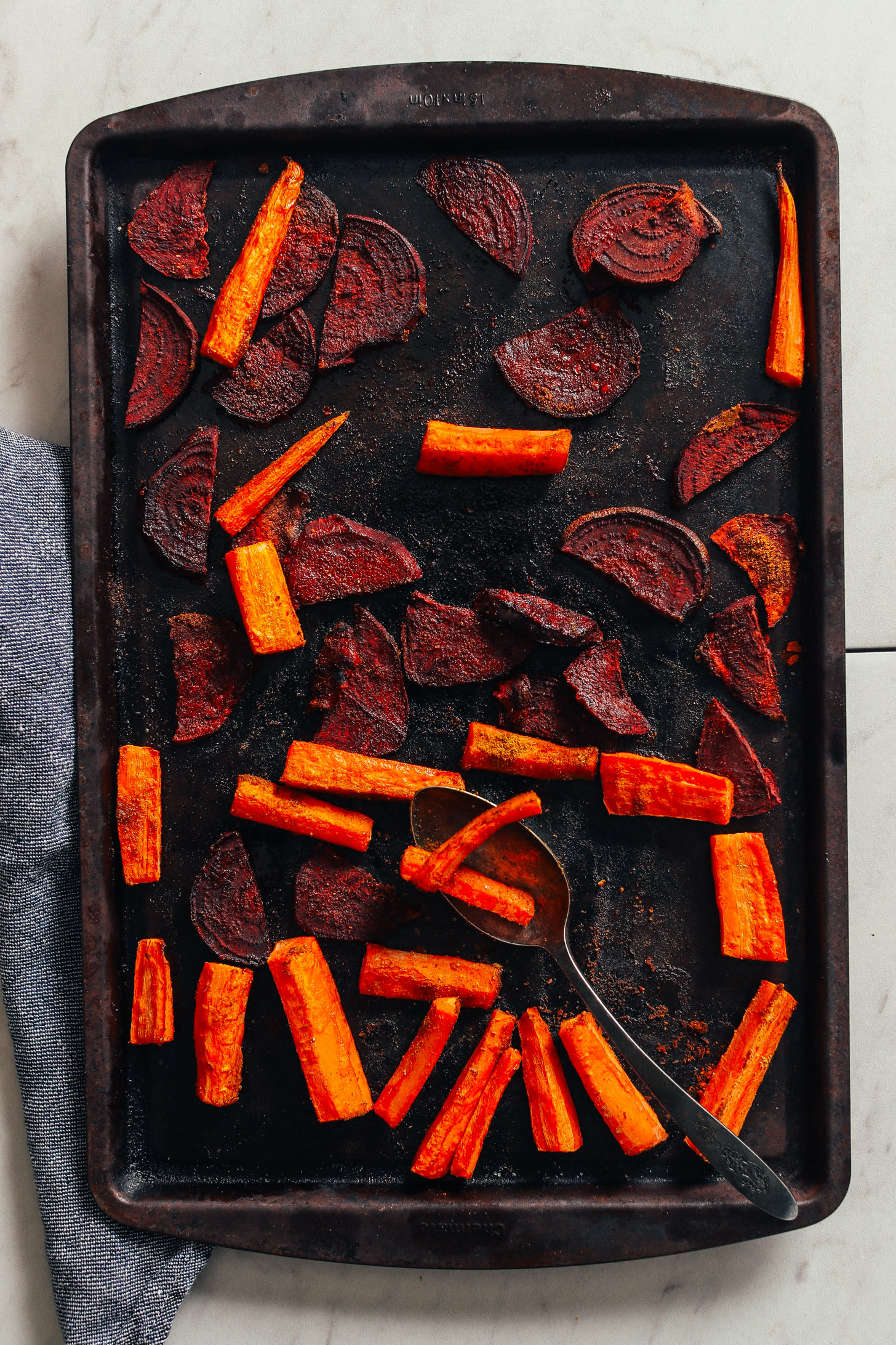 Roasted beets and carrots on a baking sheet for Loaded Kale Salad