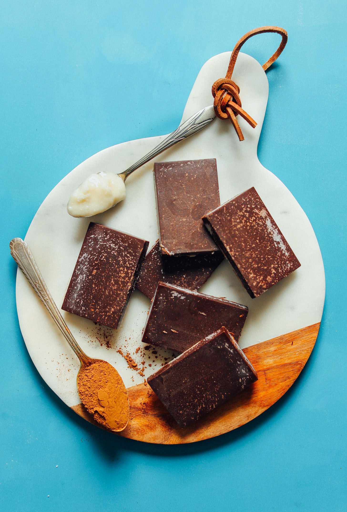 Several Sugar-Free Coconut Carob Bars alongside a spoonful each of coconut butter and carob powder
