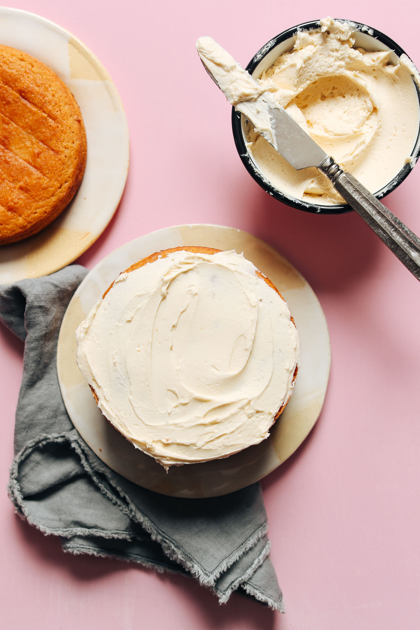 Spreading frosting on one of the layers of this 1-Bowl Vegan Gluten-Free Vanilla Cake