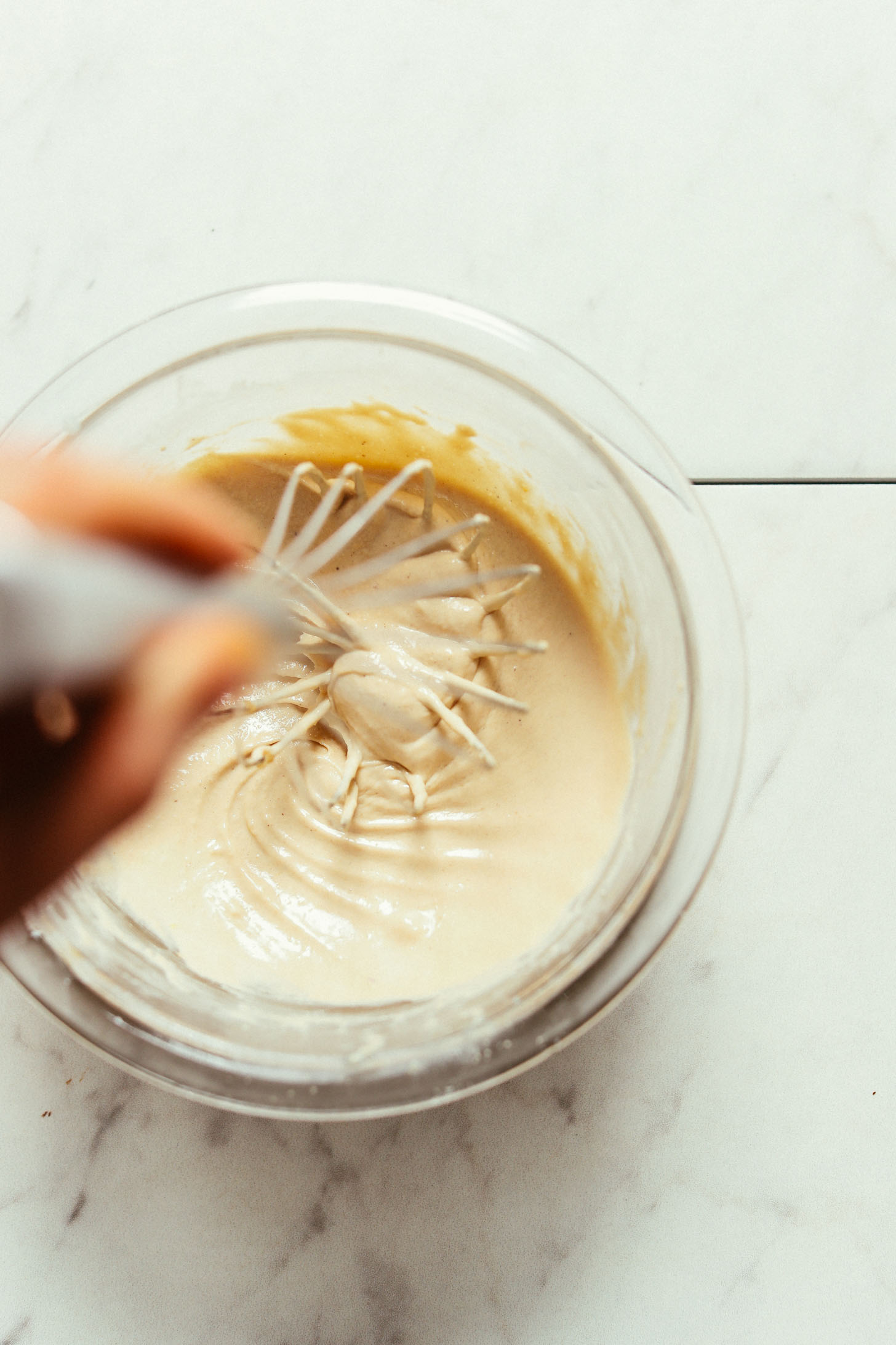 Whisking together our vegan Savory Tahini Dressing in a glass mixing bowl