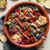 Large wood bowl with Baked Quinoa Black Bean Falafel over green salad
