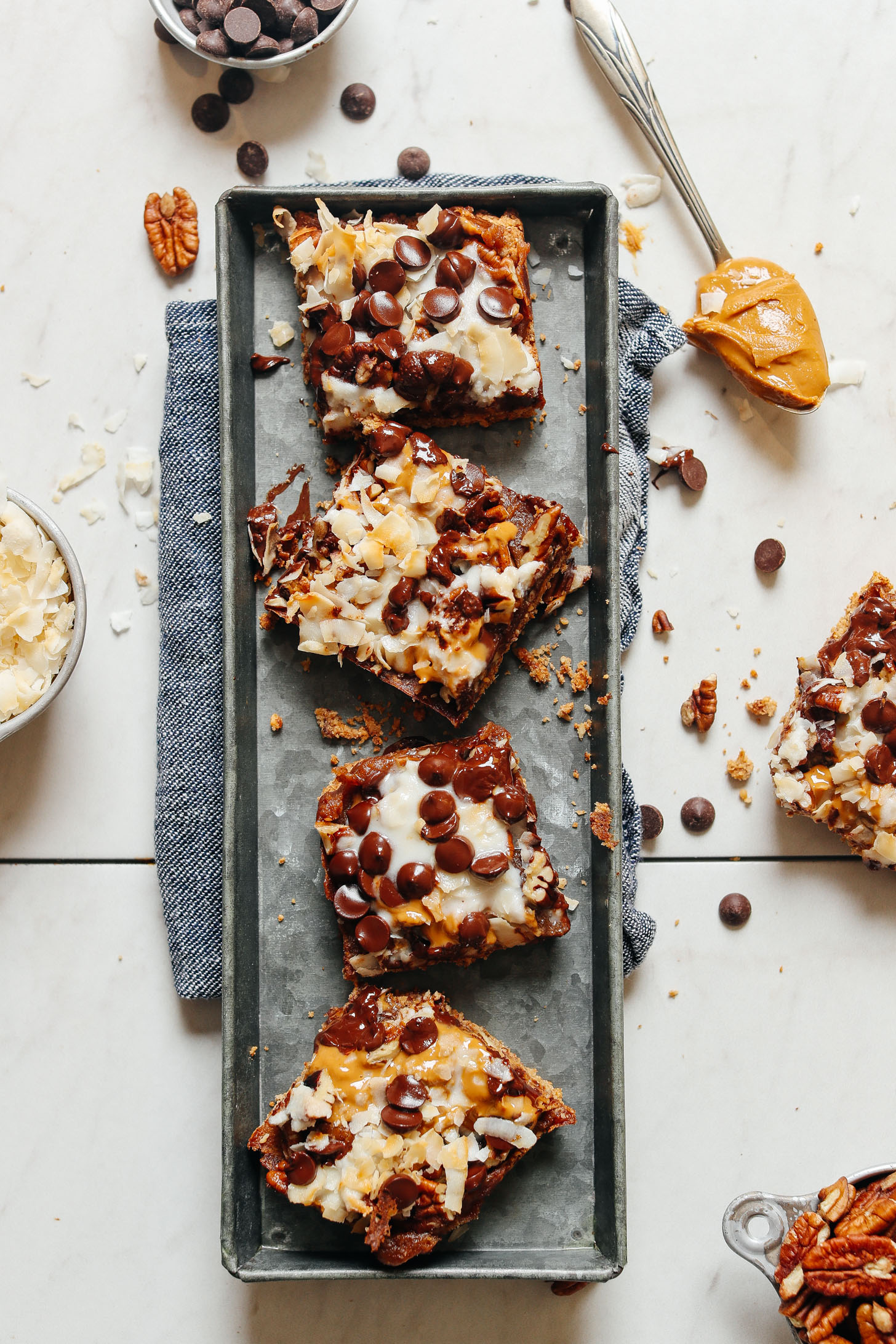 Metal serving tray displaying four gooey and decadent Vegan 7-Layer Bars