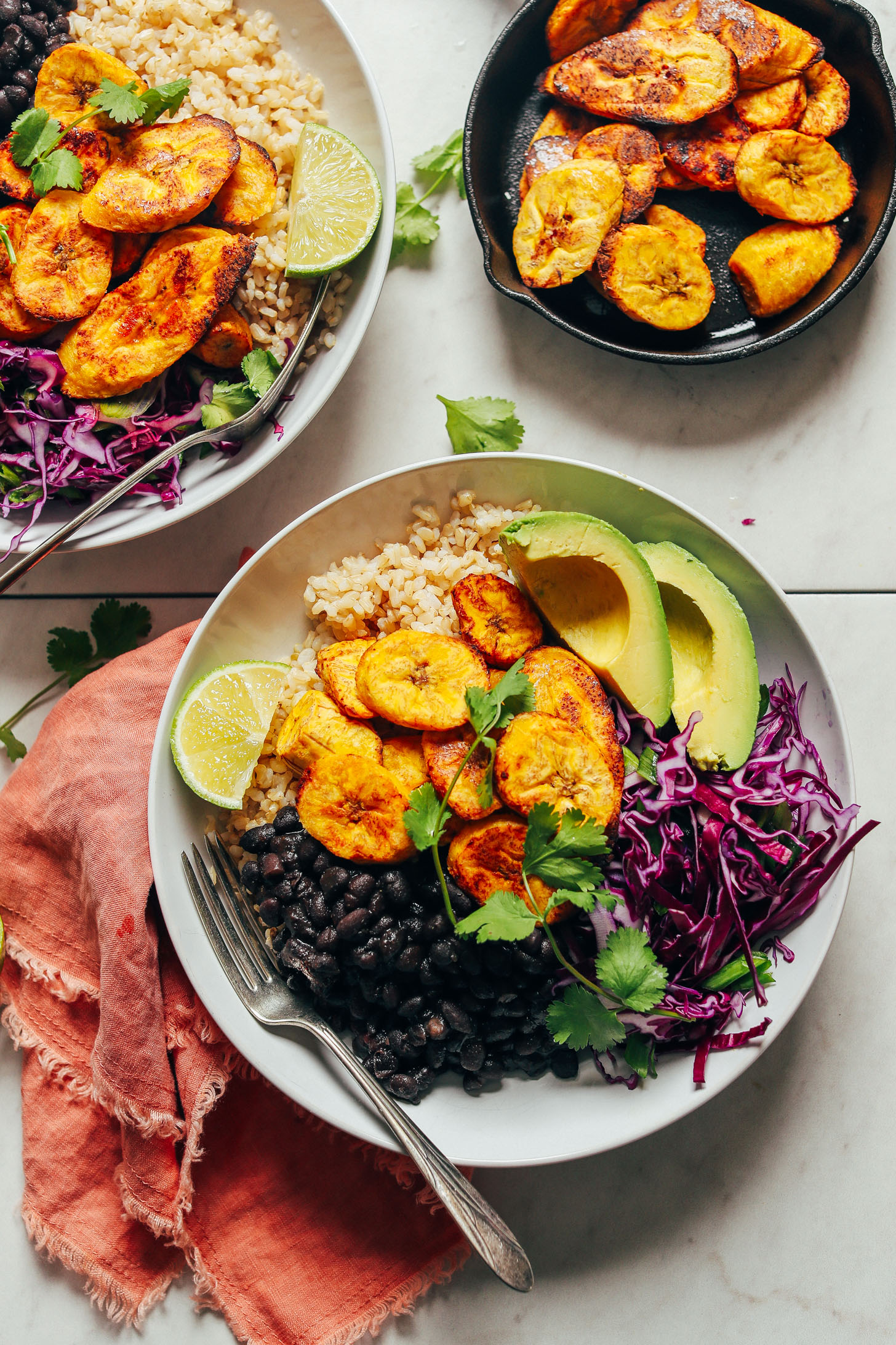 Dinner bowl filled with beans, rice, plantains, cabbage, avocado, and cilantro for easy to make Black Bean Plantain Bowls