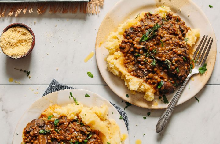 Plates of Lentil Mushroom Stew topped with fresh thyme served over mashed potatoes