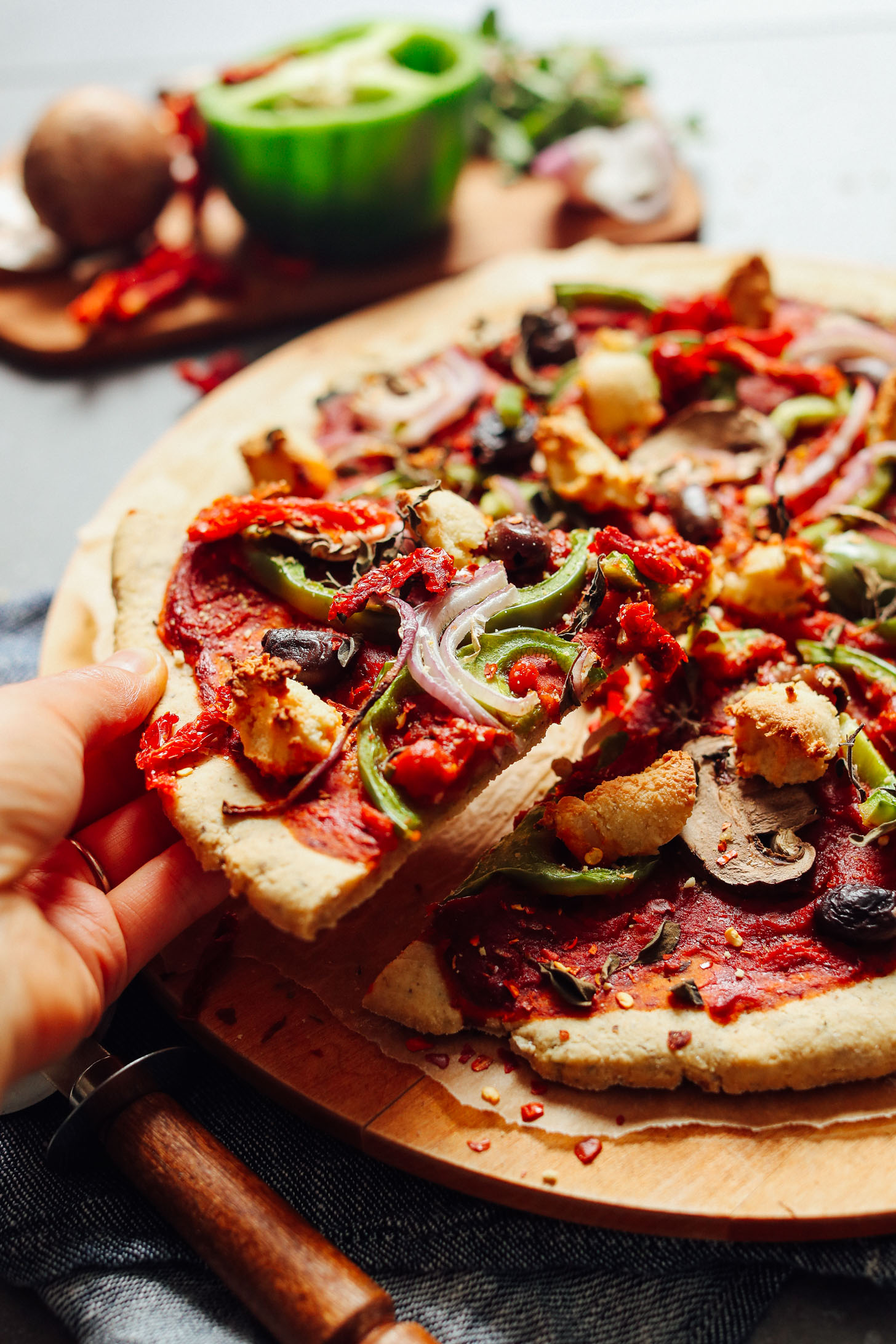 Close up shot grabbing a slice of delicious homemade vegan & gluten free pizza