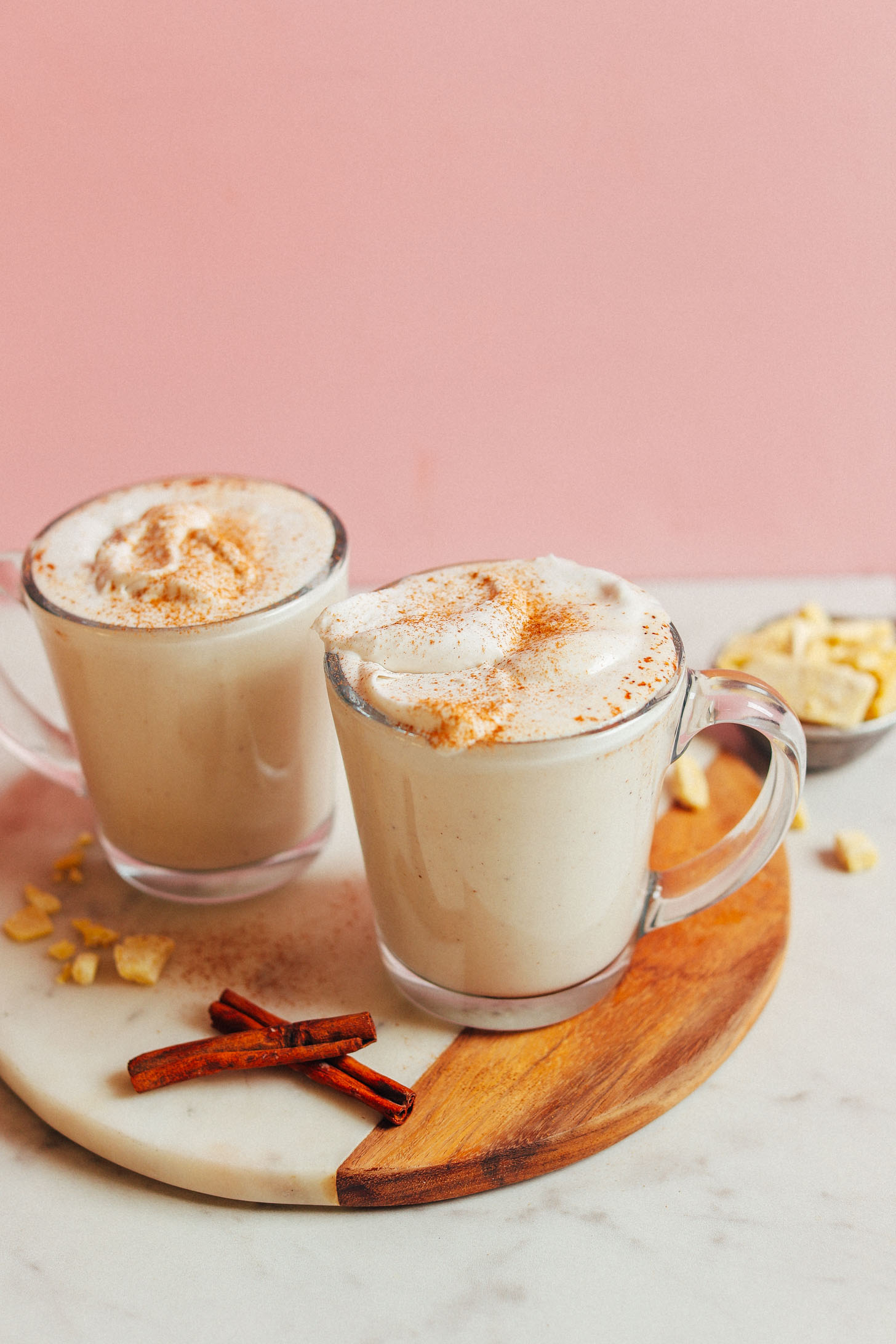 Two mugs of our vegan White Hot Chocolate recipe topped with coconut milk whipped cream