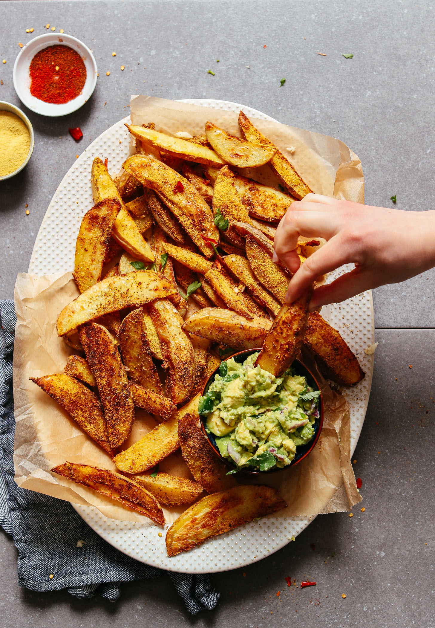 Dipping a Potato Fry with Cheesy-Chili seasoning into a bowl of guacamole