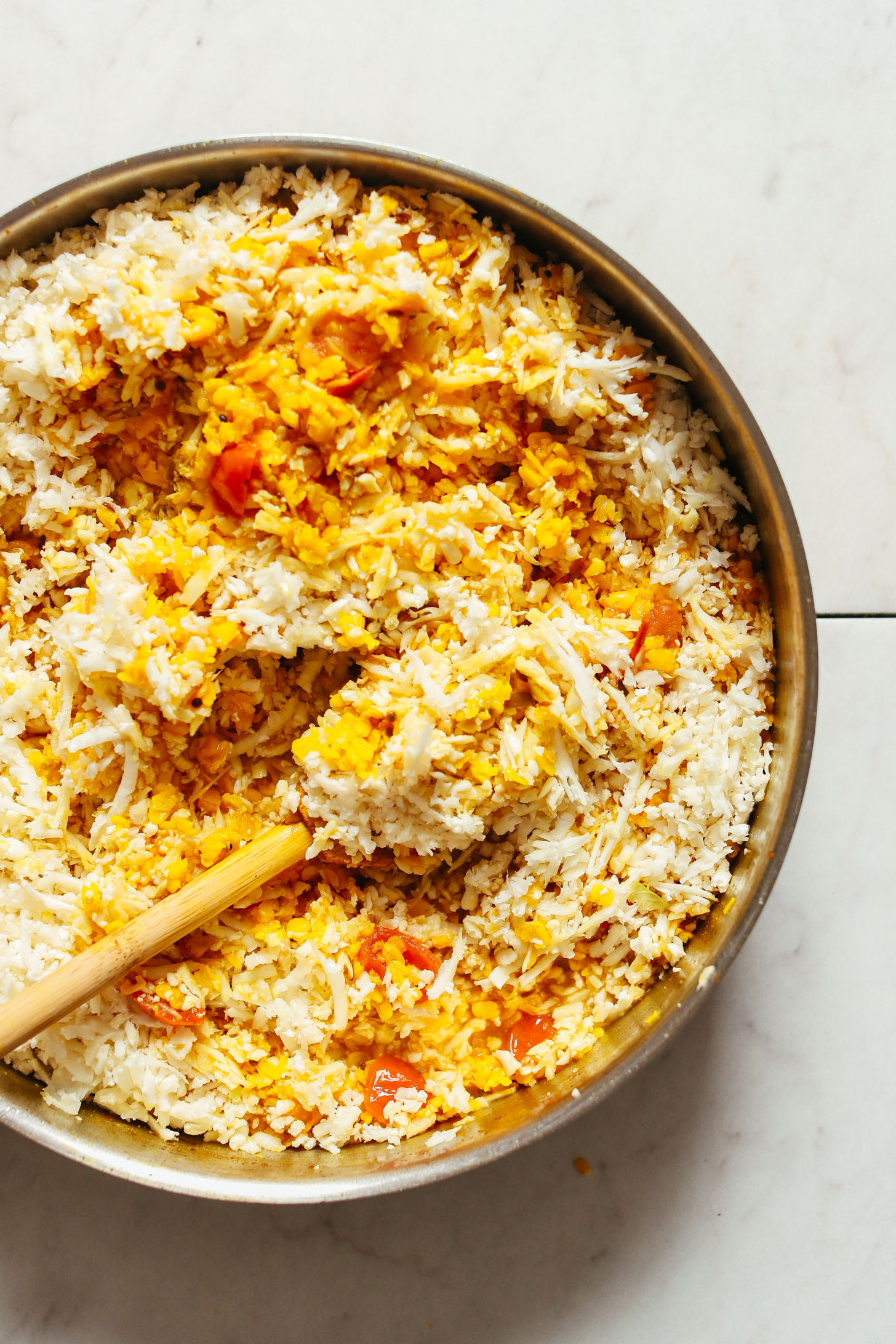 Stirring cauliflower into super soothing 1-Pot Cauliflower Rice Kitchari for a simple plant-based meal