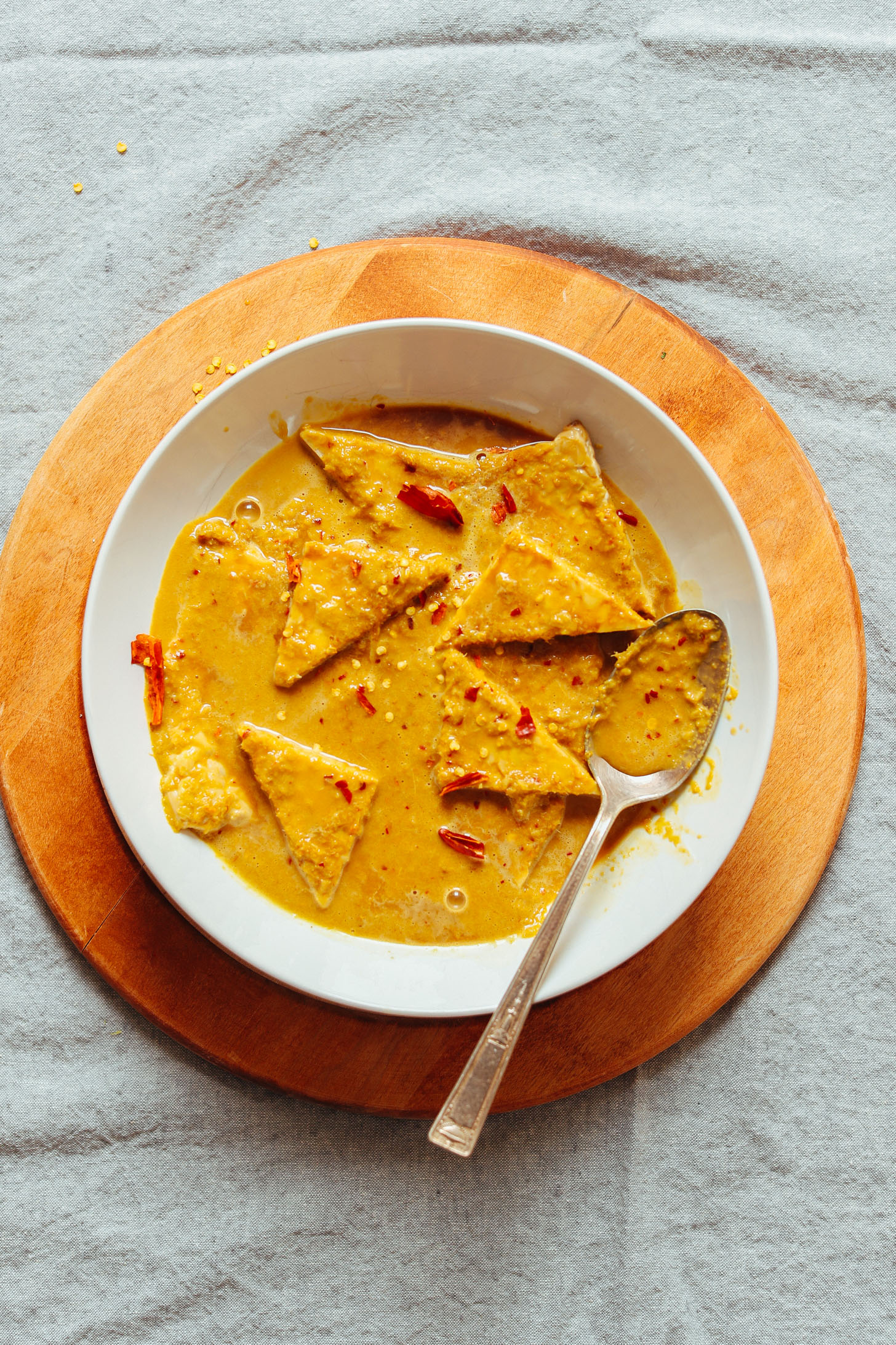Bowl of tempeh triangles marinating in vegan Lemongrass Satay sauce