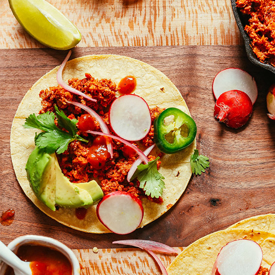 Cutting board with a taco made with our delicious Vegan Taco Meat recipe
