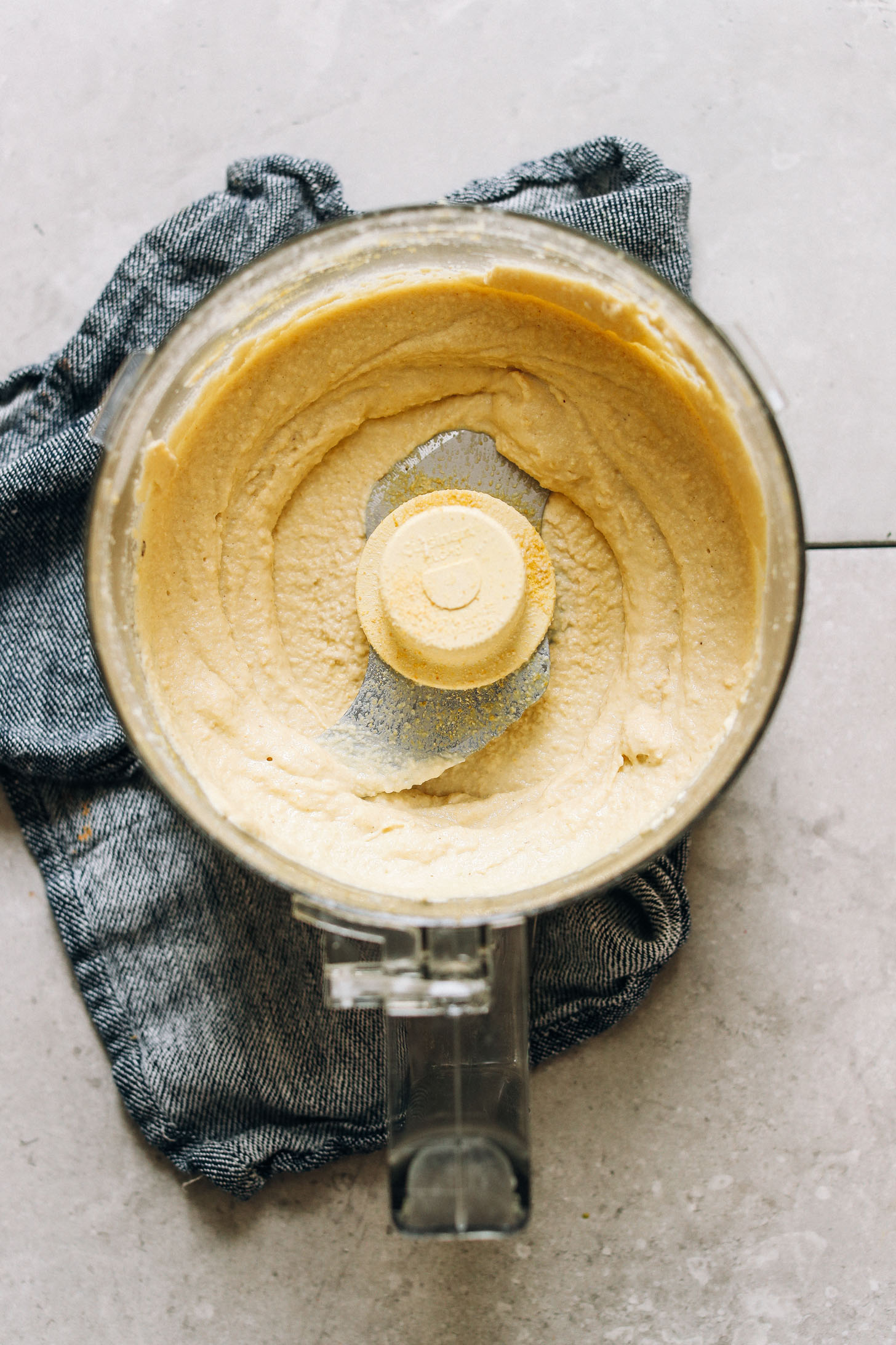 Food processor with vegan cheese sauce for adding to gluten-free spaghetti squash noodles