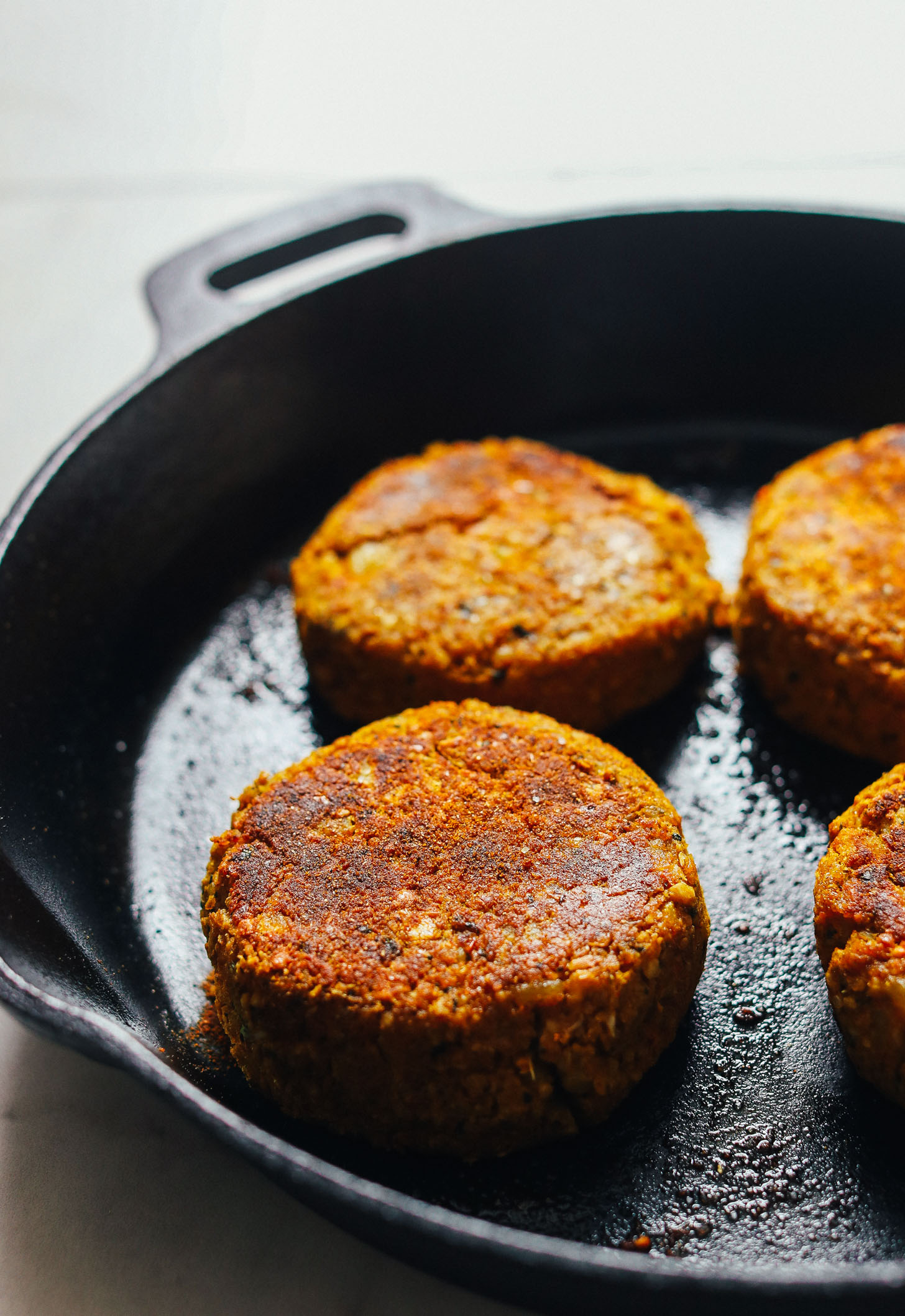 Browning Curried Chickpea Burgers in a cast-iron skillet