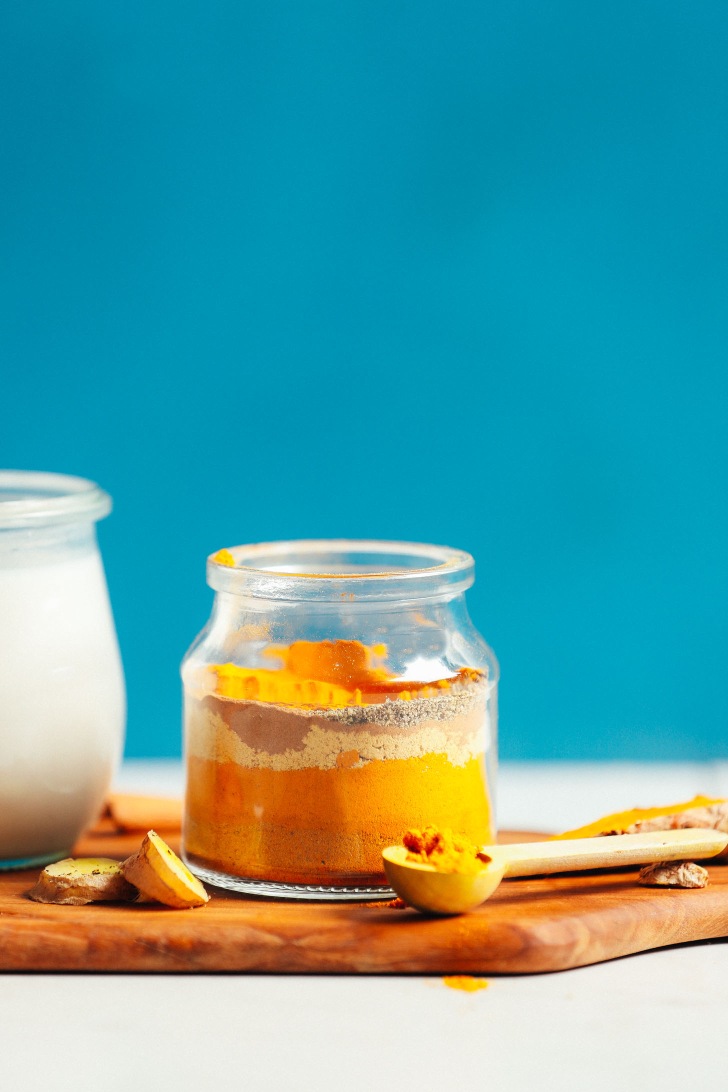 Small jar and spoonful filled with our homemade easy golden milk mix recipe