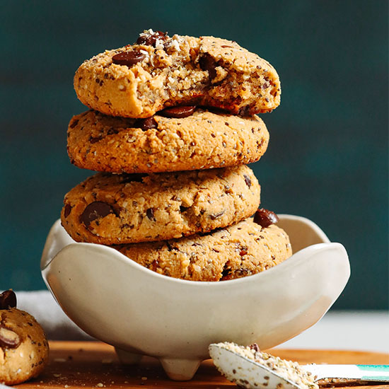 Stack of Vegan Trail Mix Cookies in a bowl with scooped sides