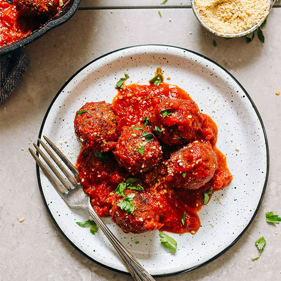 Plate of our delicious Vegan Meatballs in marinara sauce topped with parsley
