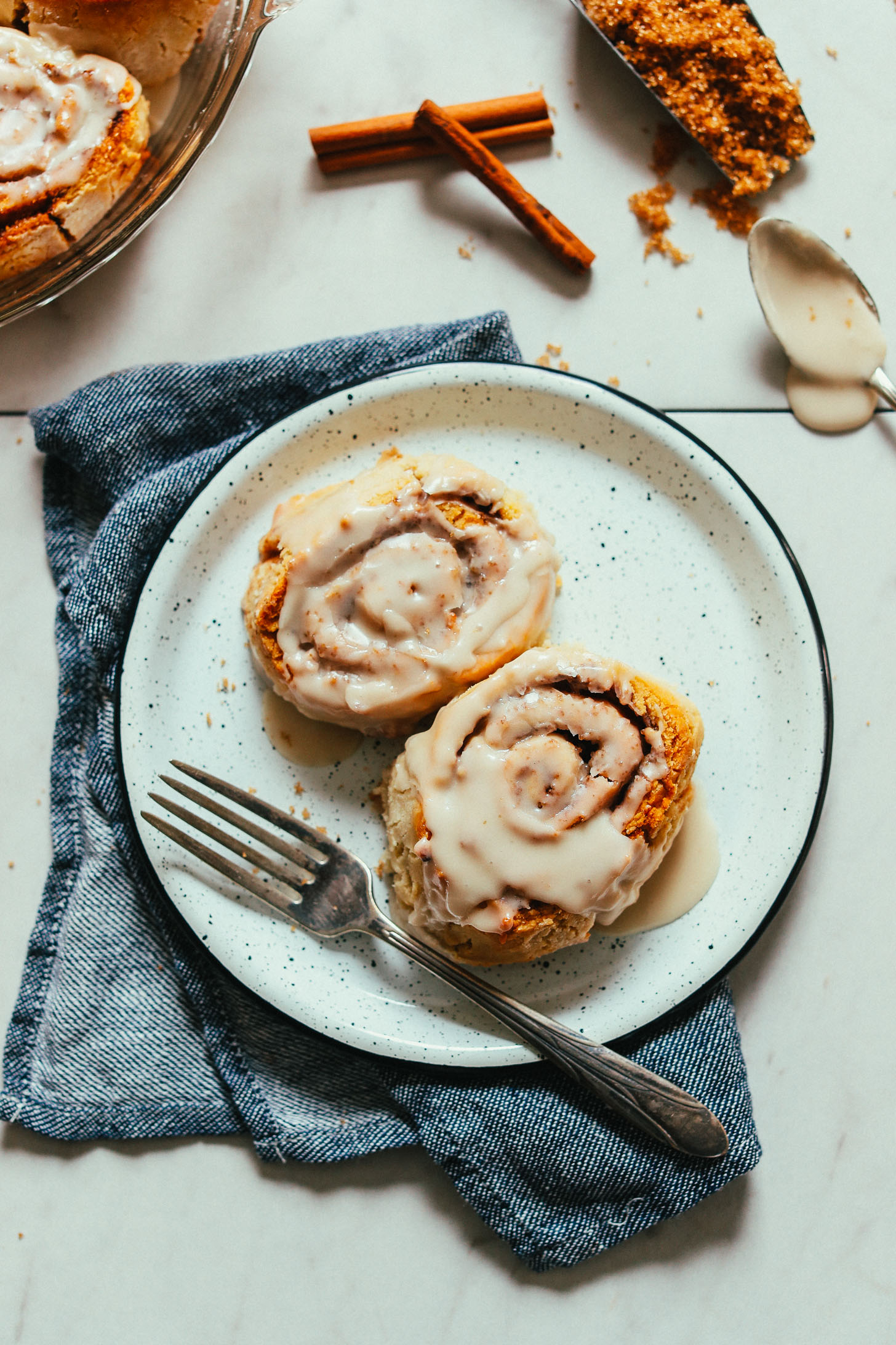 Plate of homemade Cinnamon Rolls topped with icing for a luxurious vegan dessert