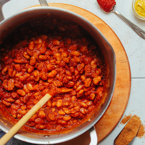 Using a wooden spoon to stir a pot of our simple 1-Pot BBQ Baked Beans recipe