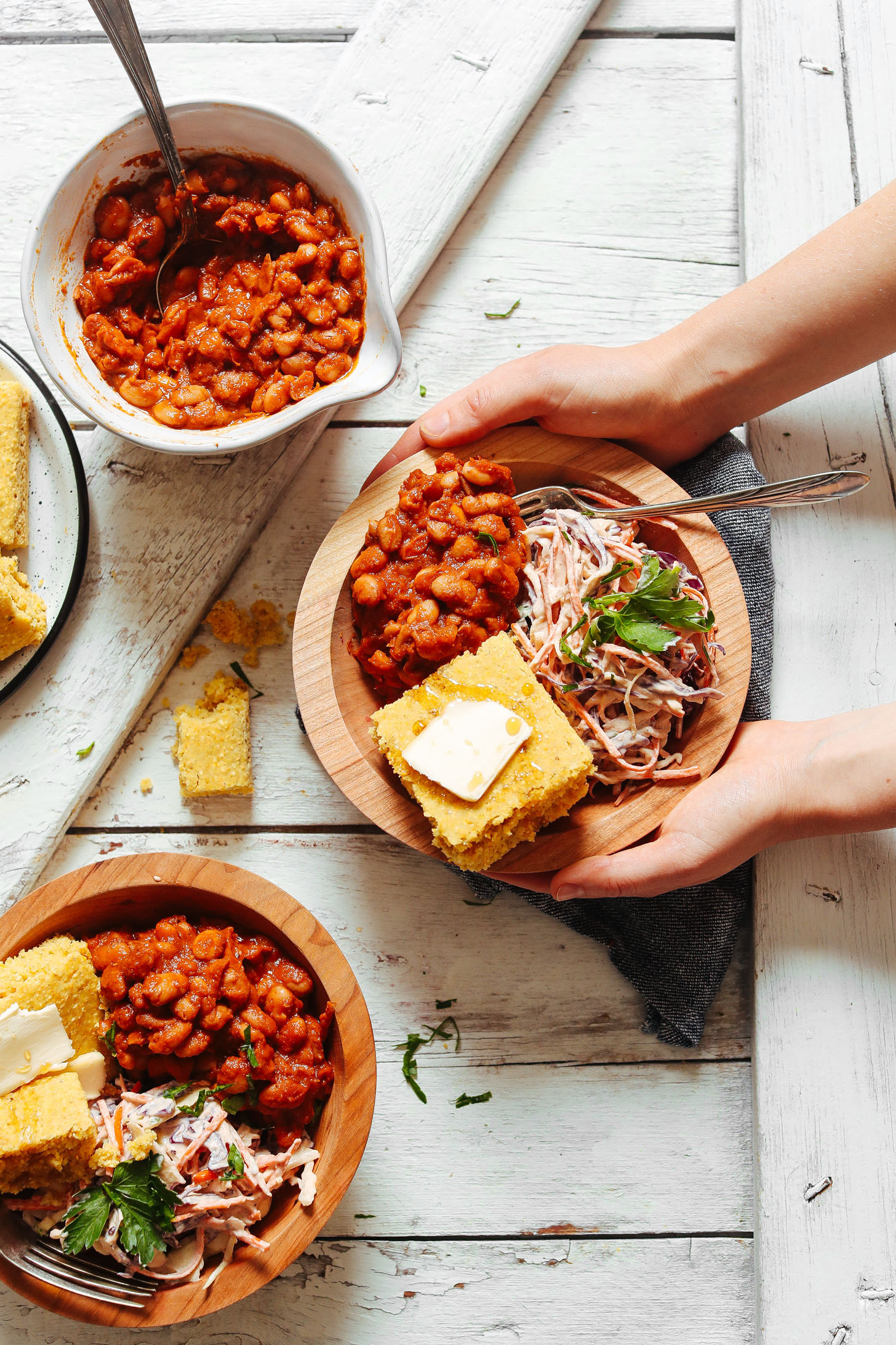Holding a BBQ Bowl with Baked Beans, Vegan Coleslaw, and GF Cornbread
