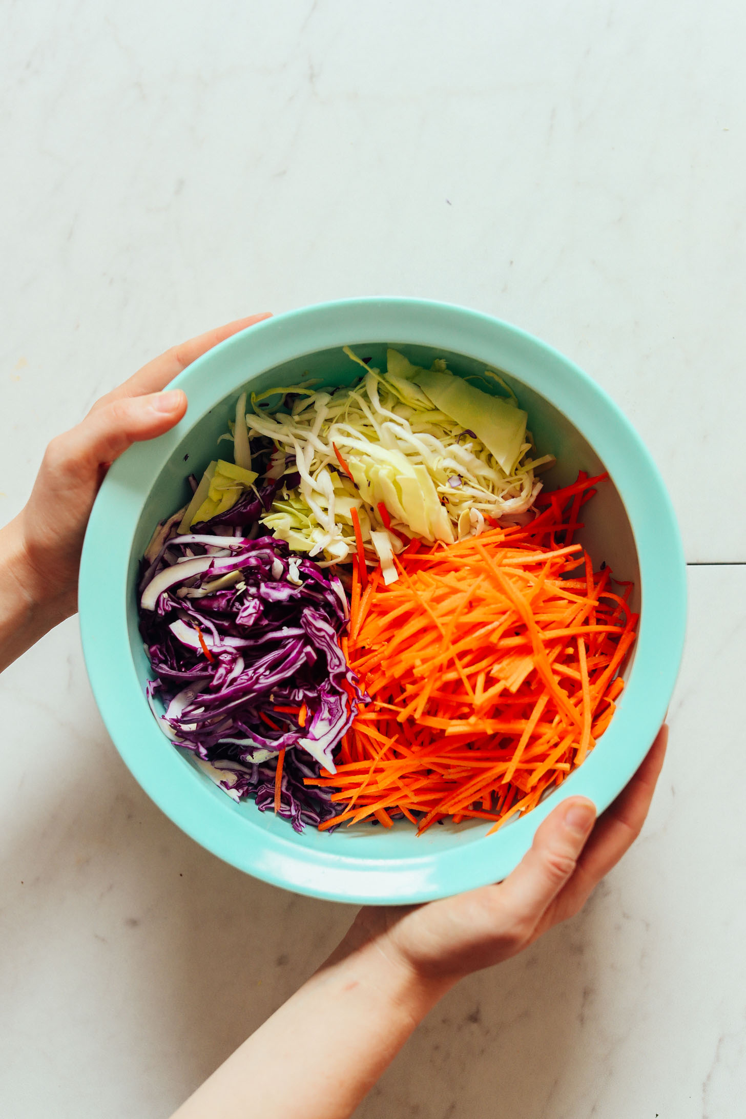 Mixing bowl filled with vegetables for homemade vegan coleslaw