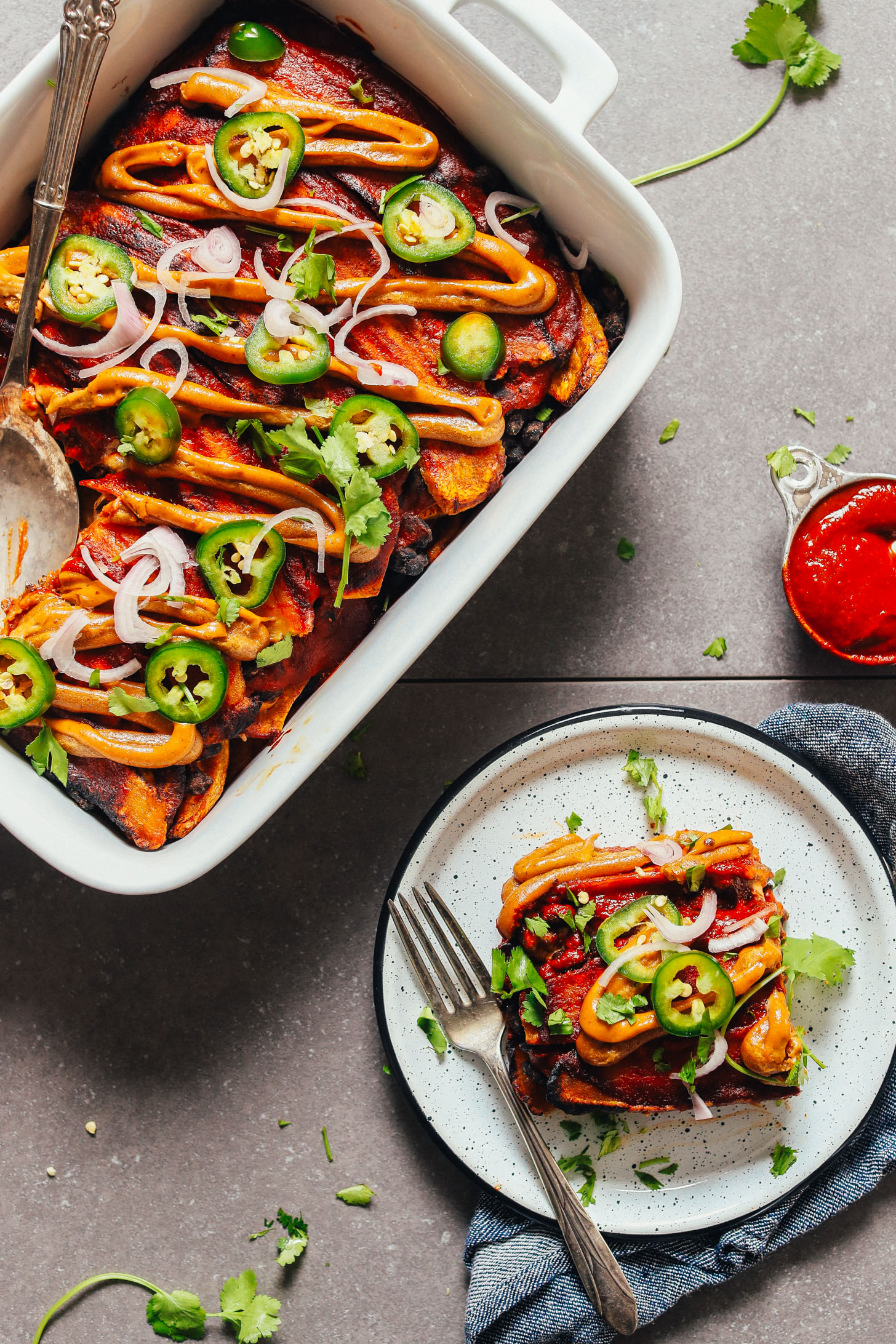 Baking dish and plate filled with our incredible Plantain Black Bean Enchilada Bake recipe