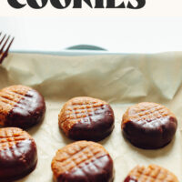 Chocolate-dipped no-bake peanut butter cookies on a tray with text above it saying just 3 ingredients