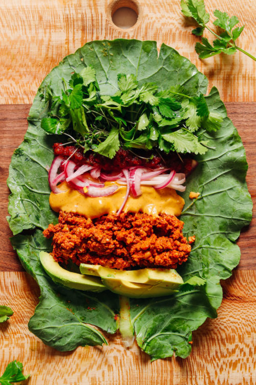 Collard green leaf loaded with ingredients such as Vegan Taco Meat and Queso