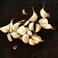 Freshly roasted cloves of garlic on a baking sheet