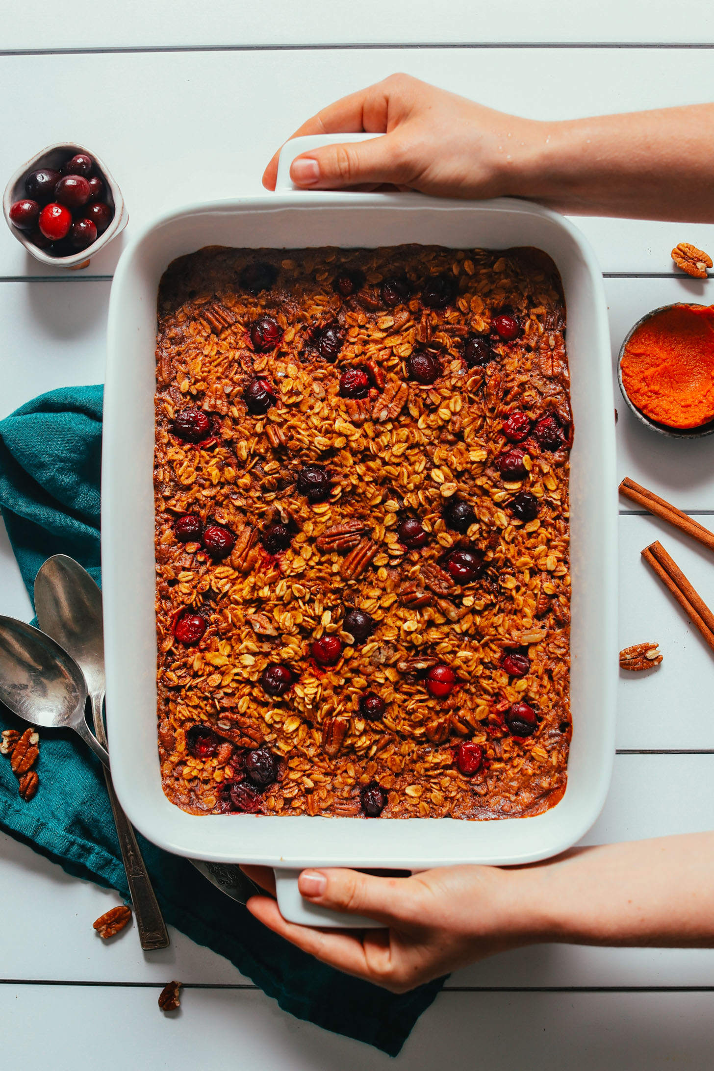 Holding a baking dish filled with naturally sweetened Vegan Pumpkin Baked Oatmeal