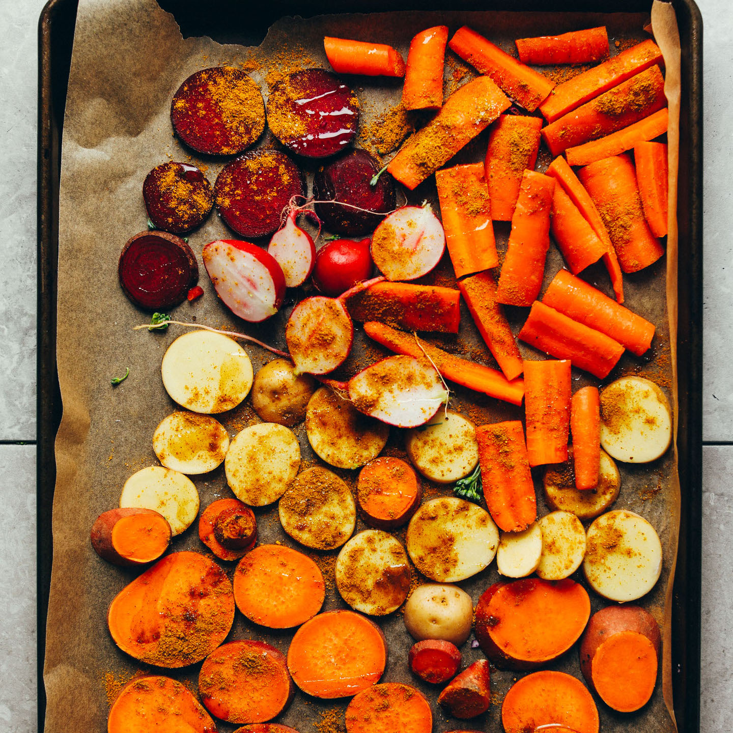 Tray of sliced carrots, beets, radishes, and sweet potatoes for roasting