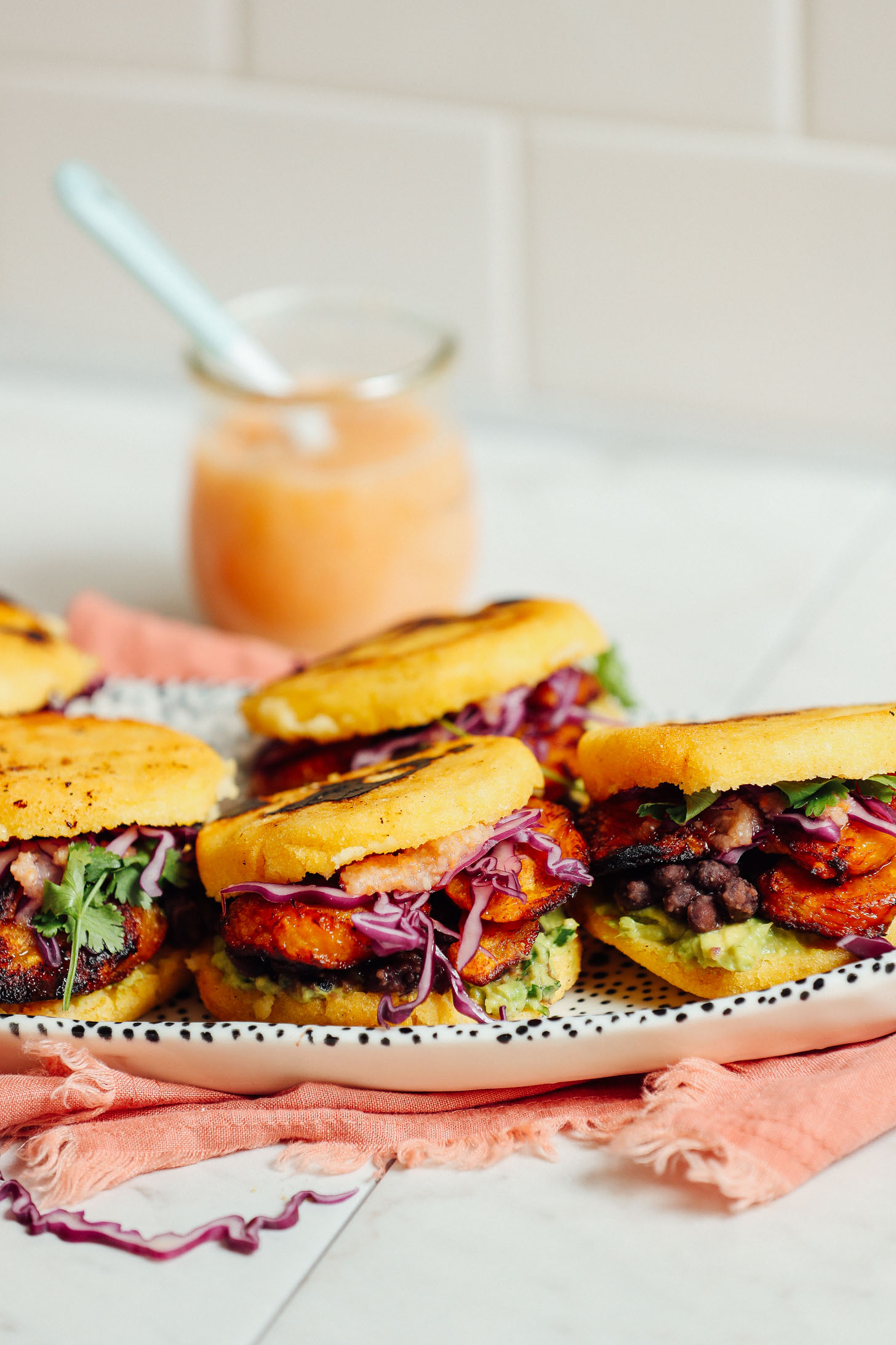 Tray with freshly made Vegan Arepa Sandwiches made with Plantains, Black Beans, and Guacamole