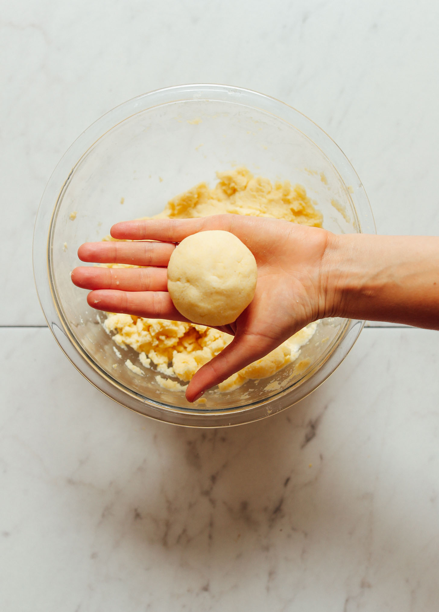 Holding a freshly rolled ball of arepa dough