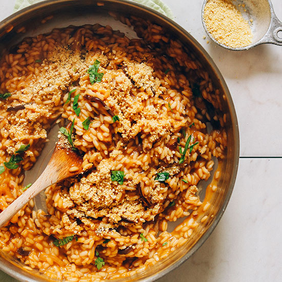 Using a wooden spoon to stir a pan of our delicious Vegan Caramelized Shiitake Mushroom Risotto