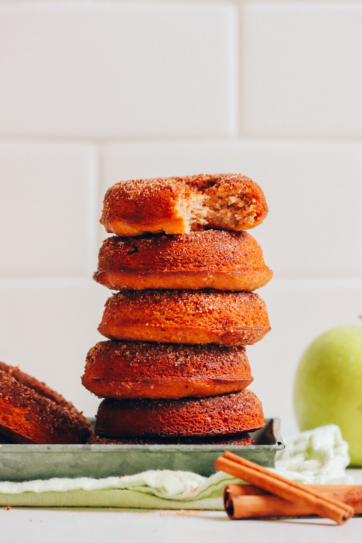 Stack of our delicious Vegan Gluten-Free Apple Cider Donuts topped with cinnamon and sugar