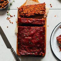 Vegan Lentil Meatloaf partially sliced on a cutting board