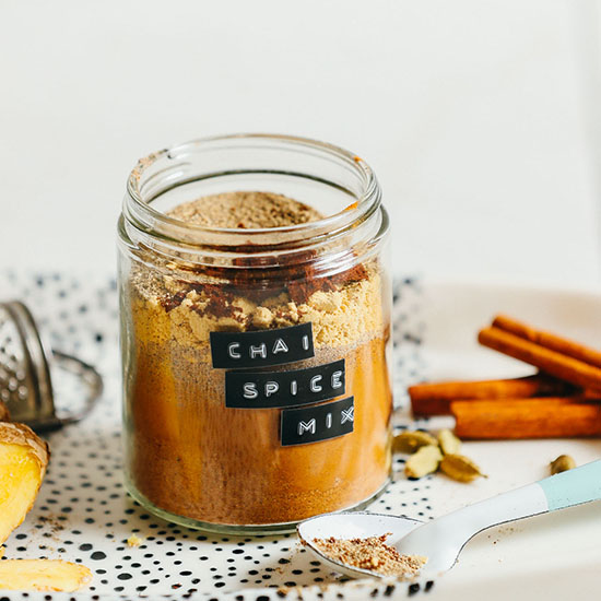 Jar of our simple homemade caffeine-free Chai Mix alongside fresh spices