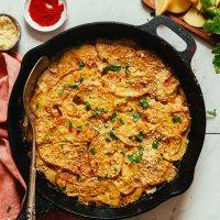 Cast-iron skillet filled with our Vegan Scalloped Potatoes recipe