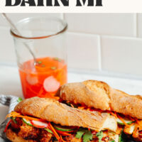 A vegan banh mi sandwich on a tray with text above it saying ready in 30 minutes