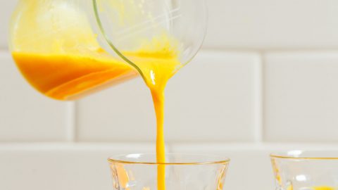 Pouring glasses of our Turmeric Wellness Shots