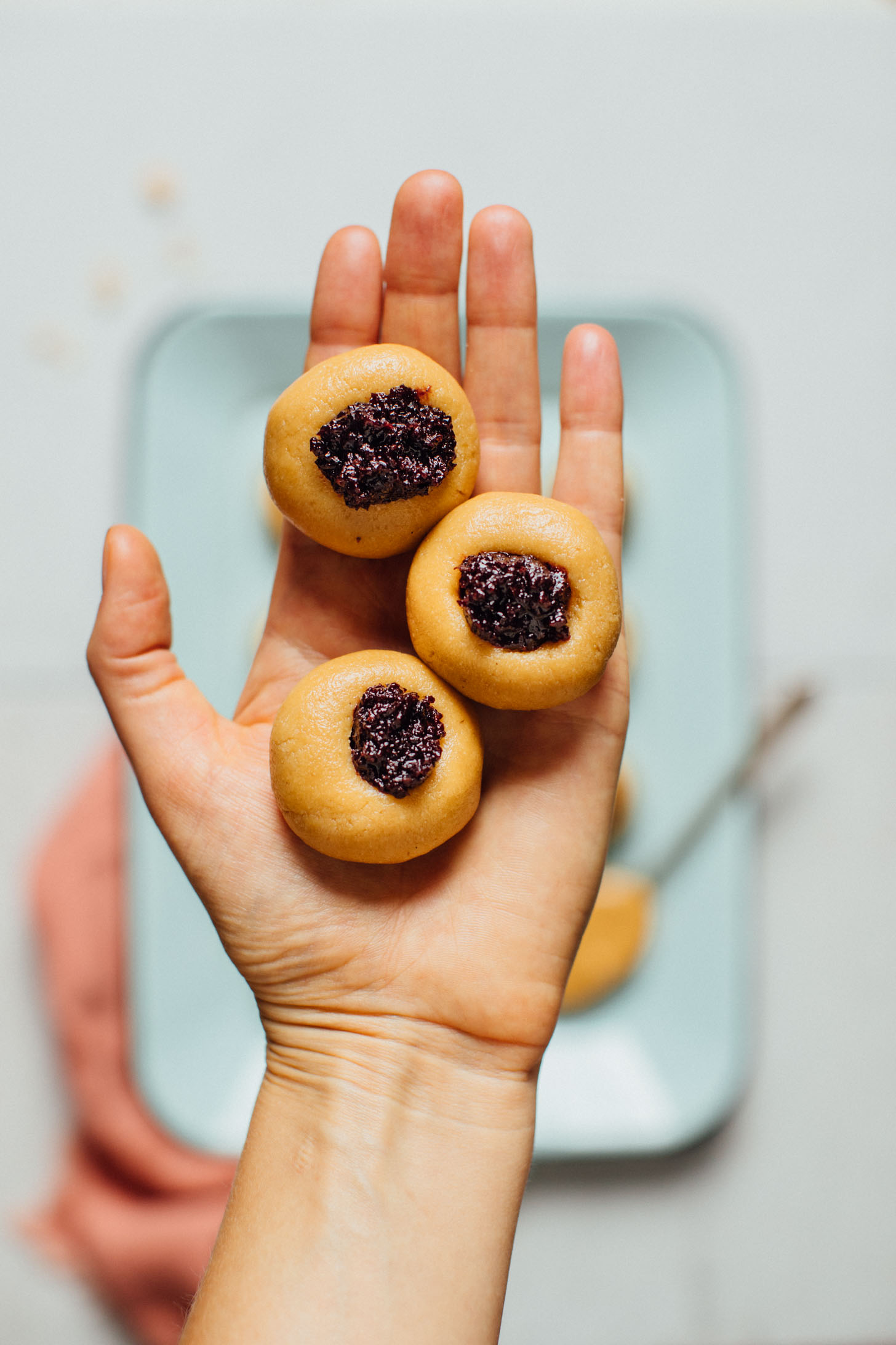 Holding up three of our delicious No Bake Peanut Butter Thumbprint Cookies