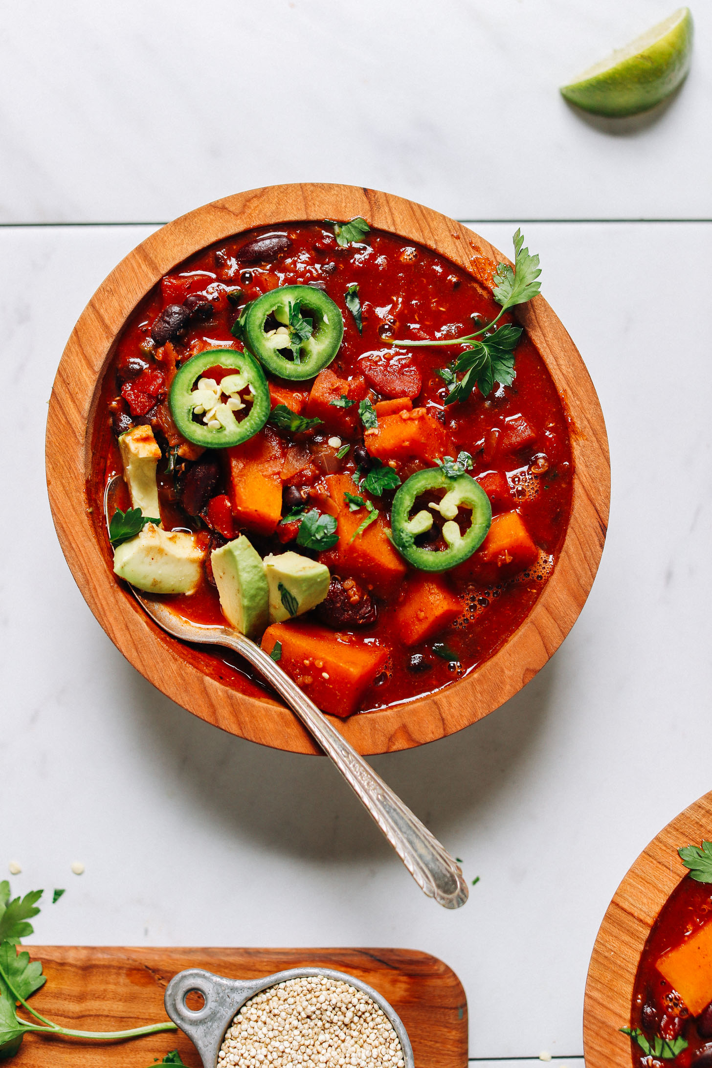 Close up shot of a bowl of our gluten-free vegan Butternut Squash Quinoa Chili topped with avocado and jalapeno