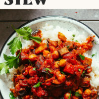 Photo of a plate of white rice topped with vegan eggplant and tomato stew inspired by zaalouk