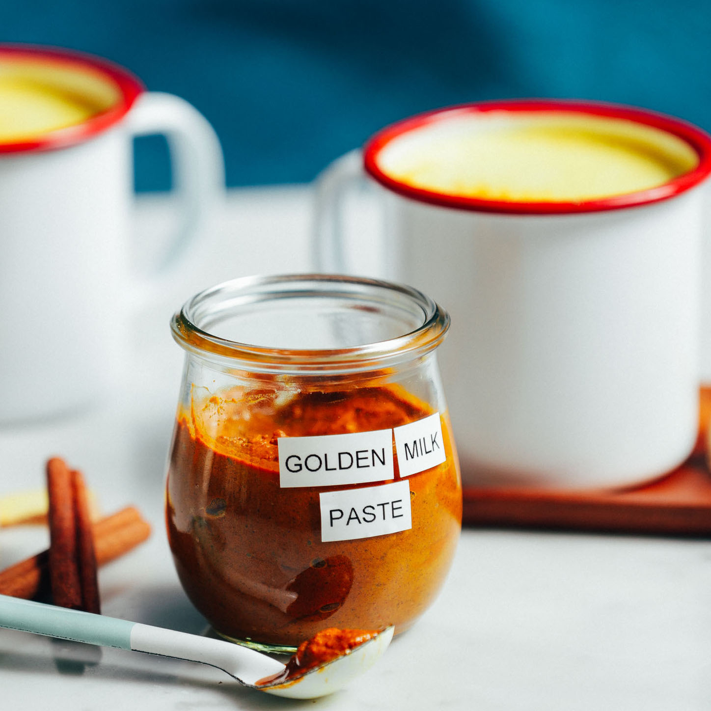 Jar and mugs of simple and delicious homemade golden milk