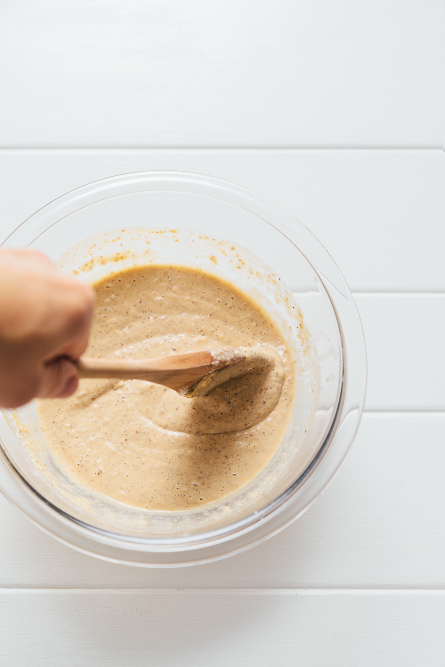 Using a wooden spoon to stir Peanut Butter Protein Pancake batter