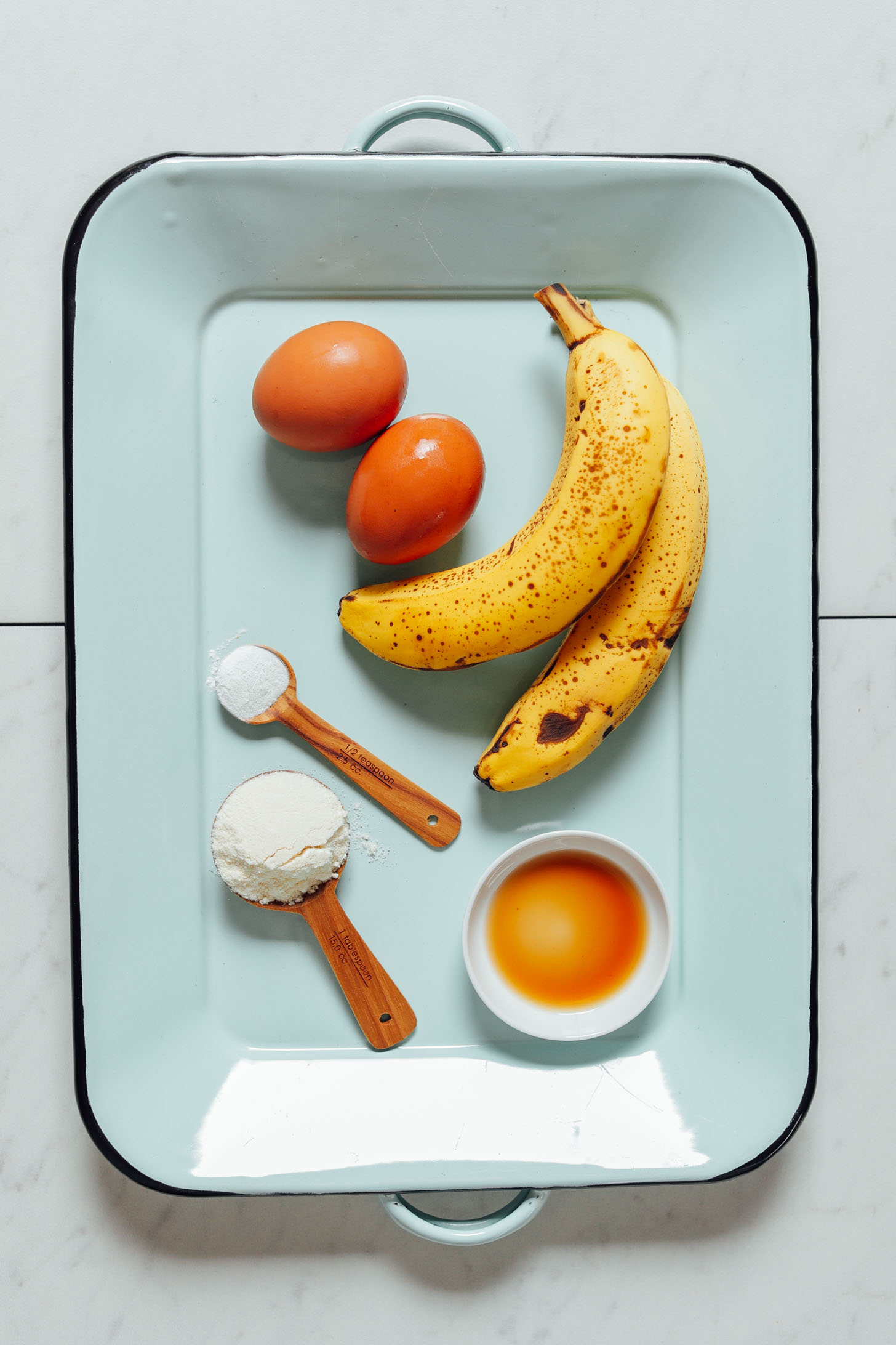 Tray with 5 simple ingredients for making Banana Egg Pancakes