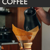 Hand pouring water from a gooseneck kettle into a chemex coffee maker
