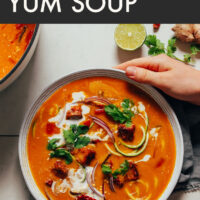 Hands holding a bowl of 1-pot vegan tom yum soup