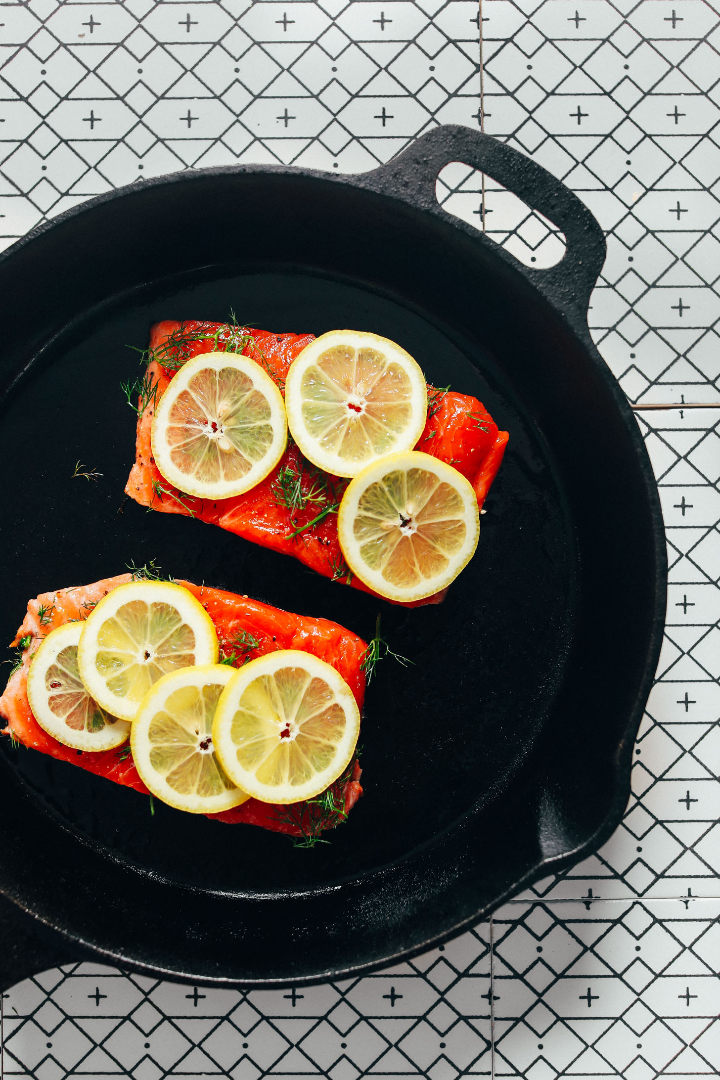 Cast-iron skillet with two filets of Lemon Baked Salmon with dill