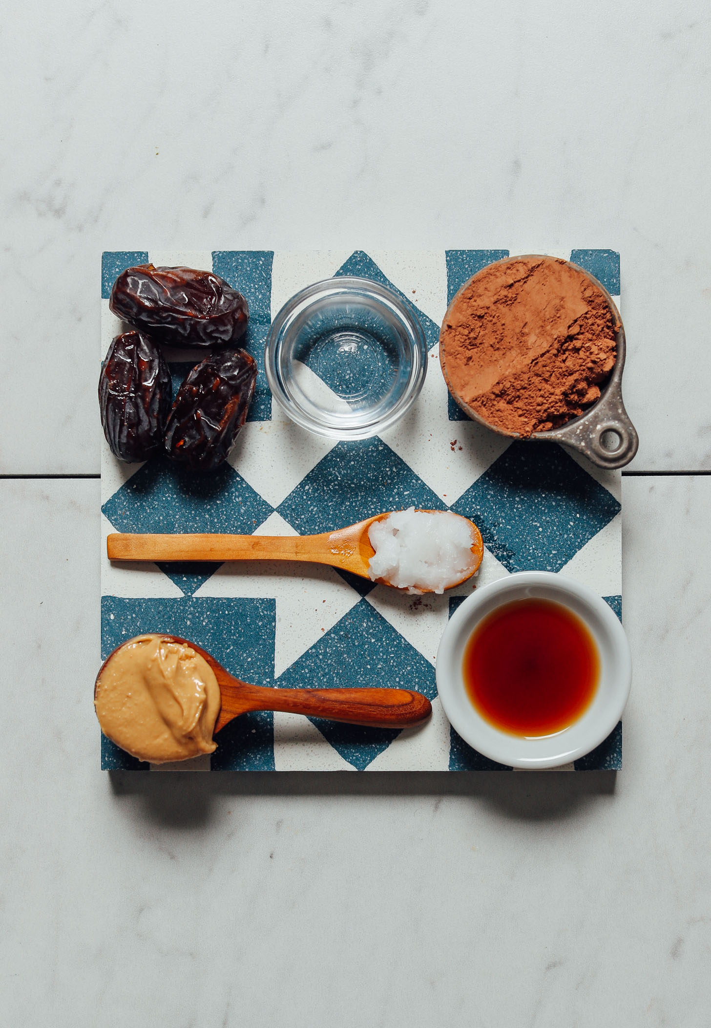 Blue and white tile with ingredients for making our Healthier Vegan Chocolate Frosting recipe