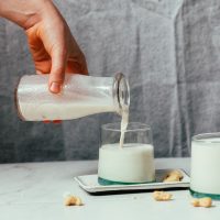 Pouring our homemade Oatly-inspired creamer into a glass