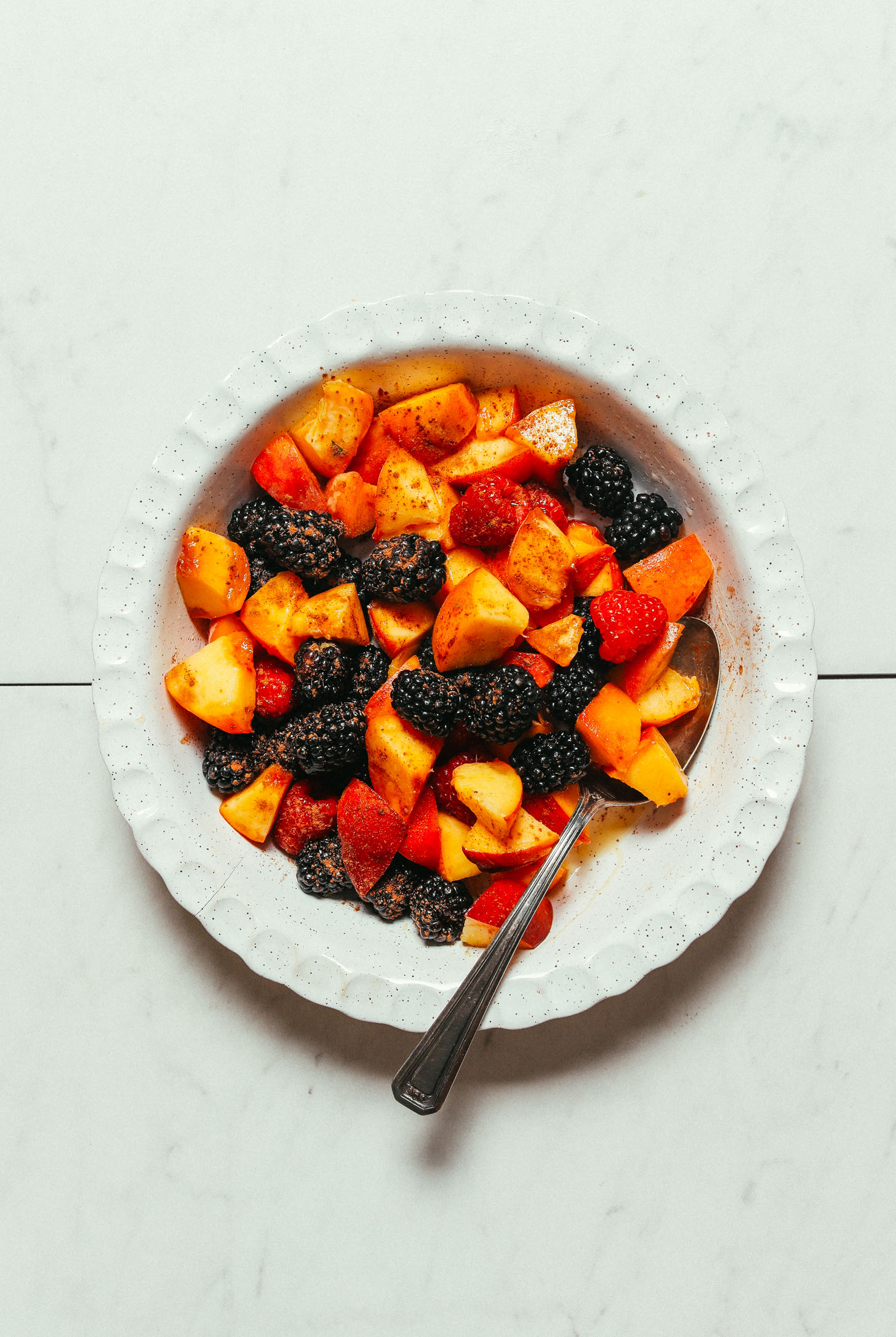 Fresh blackberries, raspberries, and peaches in a pie pan to make our Summer Fruit Crisp recipe